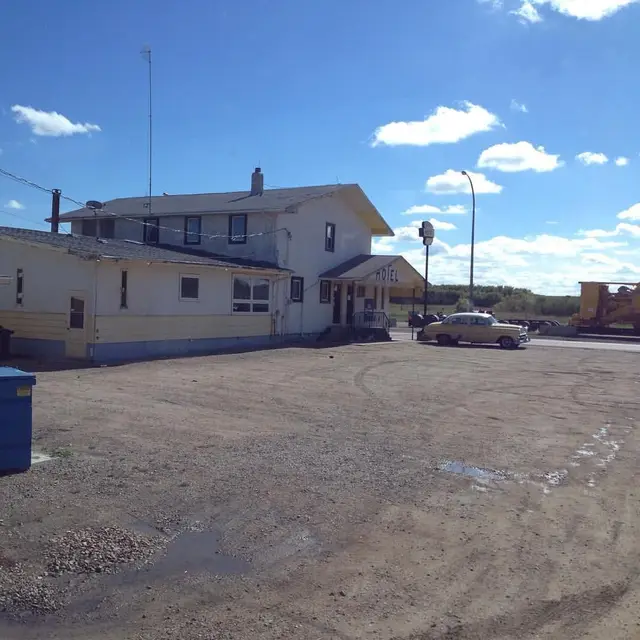 Hotel with vintage car on a gravel lot